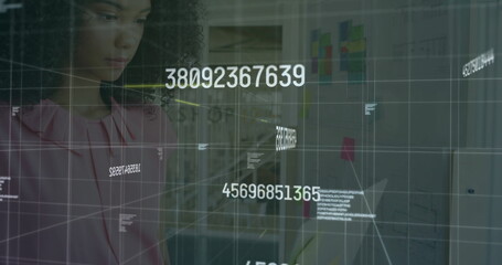 Woman in pink blouse analyzing floating numeric codes on glass board at office, planning wall