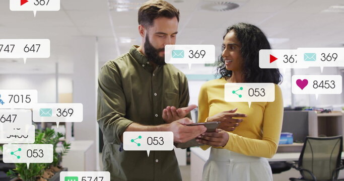 Reviewing coworkers in casual attire analyzing metrics on tablet in office with metric overlays