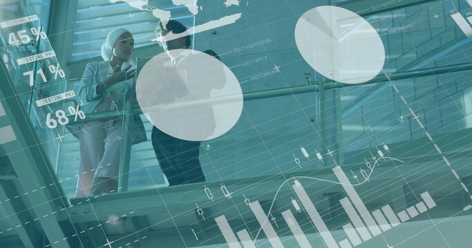 Walking colleagues in suits holding smartphone tablet on atrium walkway with charts, copy space