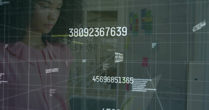 Woman in pink blouse analyzing floating numeric codes on glass board at office, planning wall