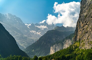 Panoramic view of the breathtaking alpine valley in Switzerland with some paragliders. 
