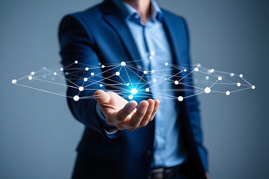 A businessman in a dark suit holds out his open palm displaying a glowing blue network of interconnected lines and nodes symbolizing technology and data - Powered by Adobe