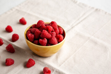 Organic Raw Red Raspberries in a Bowl, side view. Copy space.