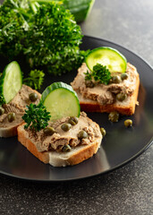 Open sandwiches with pate, fresh cucumber, capers, and parsley.