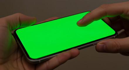 Hands holding smartphone with bright green screen, ready for custom content insertion