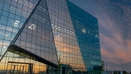 Lakewood, NJ, USA - August 27, 2025 - Large Modern Business Building with Sunset in Background and large reflective windows corporate geometric architecture