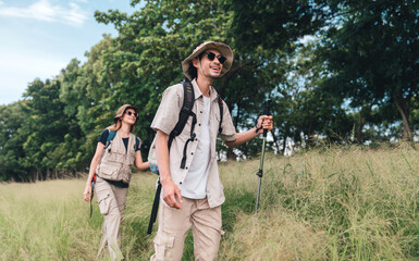Hiking Couple Walking by Lakeside Trail with Backpacks and Trekking Poles, Summer Outdoor Exploration Adventure Travel and Active Lifestyle