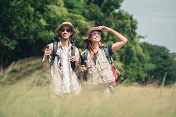 Hiking Couple Walking by Lakeside Trail with Backpacks and Trekking Poles, Summer Outdoor Exploration Adventure Travel and Active Lifestyle