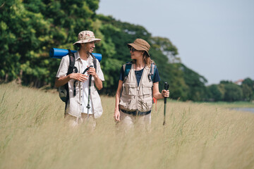 Hiking Couple Walking by Lakeside Trail with Backpacks and Trekking Poles, Summer Outdoor Exploration Adventure Travel and Active Lifestyle