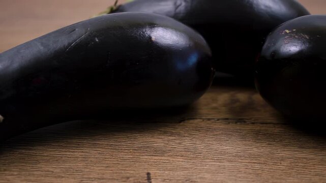 Texture of ripe dark purple eggplants. Solanum melongena fruit on a wooden board.