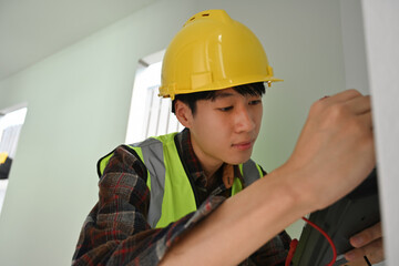 A Technician performs voltage testing on exposed wires with professional equipment
