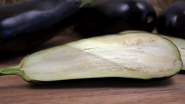 Eggplant cut lengthwise on a table:  Half of an eggplant (Solanum melongena). Detailed seed pattern