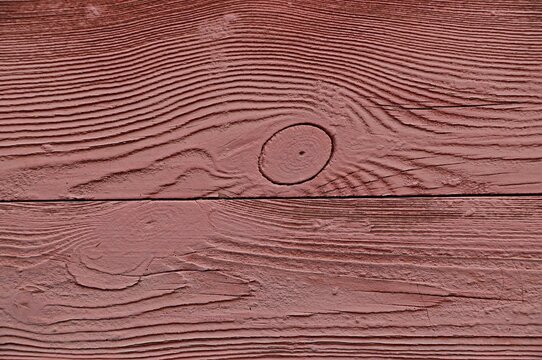 Background, texture wooden surface with knots covered with paint with a pink tint
