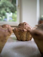 Close-up of homemade hazelnut muffins with chocolate frosting.