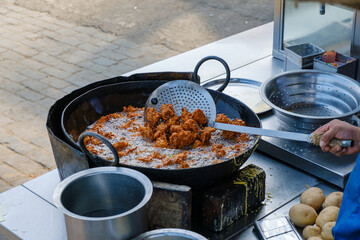 Vendor frying pakoras in Indian street side eatery