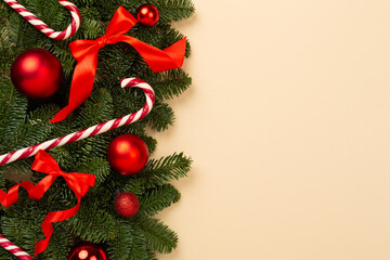 Christmas tree branches with festive decoration on color background, top view