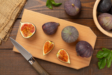Fresh tasty fig fruits on wooden background, top view