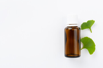 Ginkgo leaf with bottle of pills on color background, top view