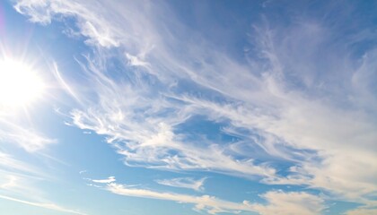Obraz premium A vibrant, light-filled azure sky is adorned with delicate, wispy clouds, showcasing a serene and tranquil atmosphere.