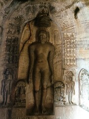 Obraz premium Ancient stone carving of a serene figure in a cave temple showcasing intricate historical details in southern India