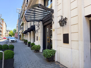 Side view of building entrance with canopy and street details. Concept of architecture, real estate, and urban lifestyle.