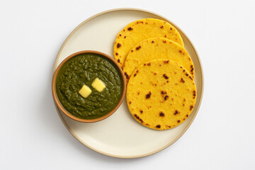 Top view of sarson ka saag with makki ki roti in plate on white background stock photo