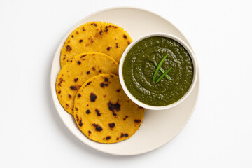 Top view of sarson ka saag with makki ki roti in plate on white background stock photo