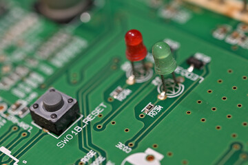 Close-up of a green and red LED on a printed circuit board.

