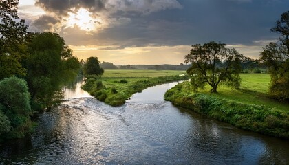 Obraz premium peaceful river flows through lush landscape under overcast skies in scenic countryside setting during late afternoon hours