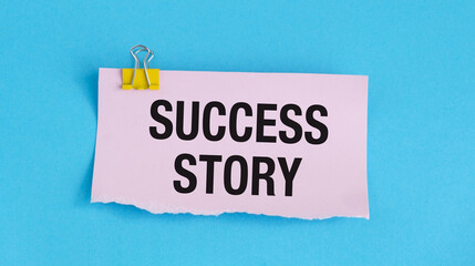 A piece of paper with the word Success Story written on it. The paper is held together with a clip
