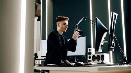 Man in professional studio adjusts photo camera, microphone while preparing for recording, surrounded by modern audio equipment, podcast lifestyle. man works in studio, preparing for podcast session