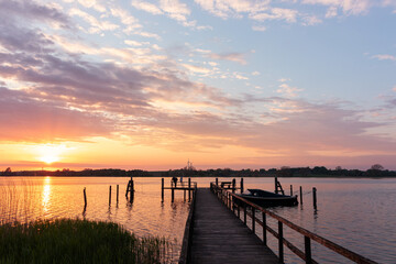 Fototapeta premium Romatic scenery with jetty and boat at the Schlei Fjord at sunset.