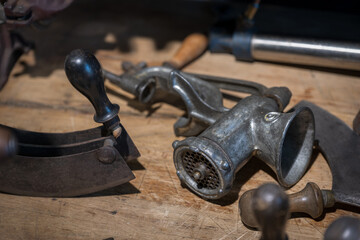 Several types of hand grinders lying on the table for meat grinding.

