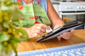 A modern grandmother searches for a pie recipe on her tablet.