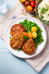 Fish burgers with vegetables on white plate. Fish patties or cakes. High angle view