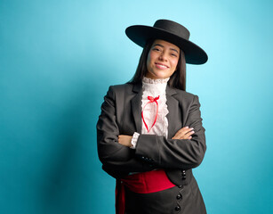 Studio portrait of a young latina woman arms crossed proudly wearing a traditional chilean huasa dress, complete with a stylish hat, patriotism	