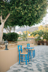 Charming Outdoor Cafe with Blue Chairs and Tables