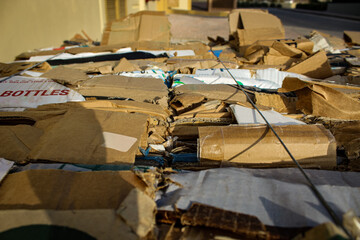 a large pile of flattened cardboard boxes ready for recycling and placed outside. commercial or industrial design element for responsible waste management. environment campaign
