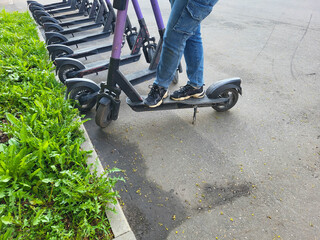 Obraz premium In the city, you can rent an electric scooter parked on the sidewalk. The concept of urban life. Eco-friendly transportation.