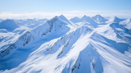 Obraz premium Snow-covered mountain peaks under clear blue skies in a remote alpine region during winter season