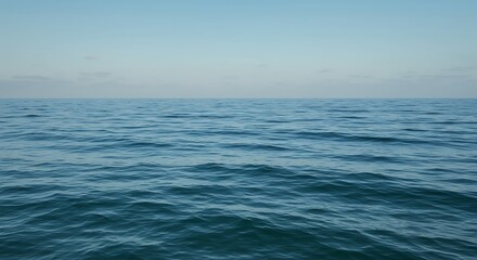 Obraz premium Serene azure expanse of the ocean meeting a clear cerulean sky under gentle sunlight