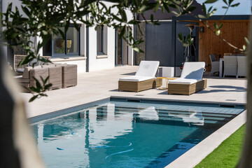 Piscine contemporaine intégrée dans un jardin moderne avec pelouse soignée et aménagement paysager élégant.