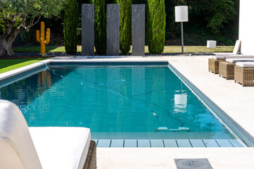 Piscine contemporaine intégrée dans un jardin moderne avec pelouse soignée et aménagement paysager élégant.