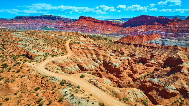 Aerial Desert Road Winding Through Red Rock Canyons and Mesas Utah - Powered by Adobe