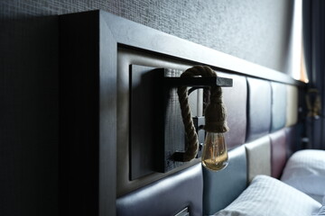 Naklejka premium Close-up of an original loft-style bedside lamp. The lamp consists of an Edison lamp