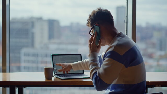 Busy manager talking mobile phone cityscape office closeup. Guy typing computer - Powered by Adobe