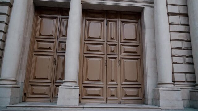 Triple oversized entrance portals constructed from pale timber leading into grand exhibition space or hall viewed directly from the front
