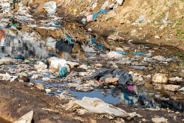 Polluted waterway overflowing with garbage near urban area shows critical need for environmental action