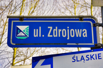 Ustroń Zawodzie - słynne piramidy. Niebieski znak drogowy wskazujący ulicę Zdrojową z herbem regionu, położony na Śląsku. © Pol Badger