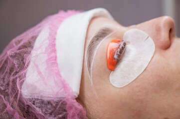 Caucasian woman undergoing eyelash lamination procedure. 